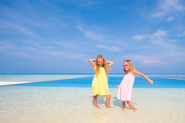 Adorable little girls playing in outdoor swimming pool