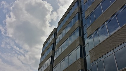 modern office building with clouds reflected in windows,front at angle