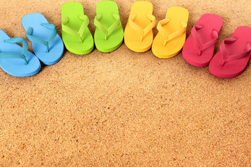 Row line semi circle border of flip flops flipflop summer beach sandals on a sand background team...
