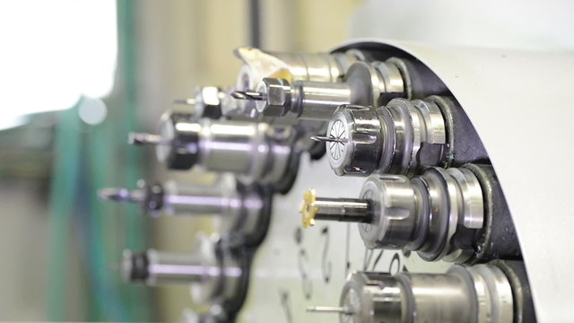 Automatic tool changer rotating bits with tools at CNC lathe milling center 