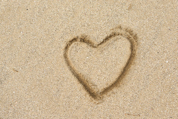 Heart shape drawing on a sand beach