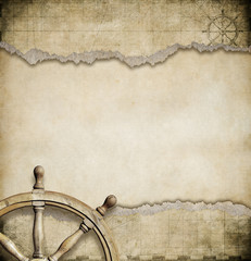 old steering wheel and torn nautical map background
