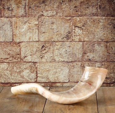 shofar (horn) on wooden table in front of jerusalem window