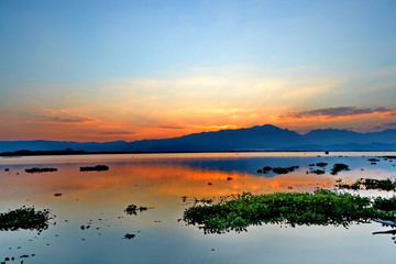background sun filtered cloudscape morning sunrise over silhouetted mountains