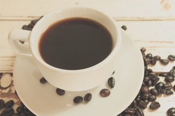 coffee cup and coffee beans on white wooden, process color with