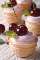 small cakes with creamy cream and fresh cherries