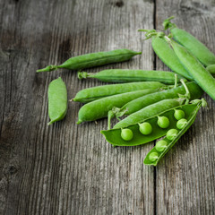 fresh green peas over a rustic wood table