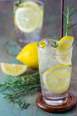 Lemonade with fresh lemon and rosemary in glass