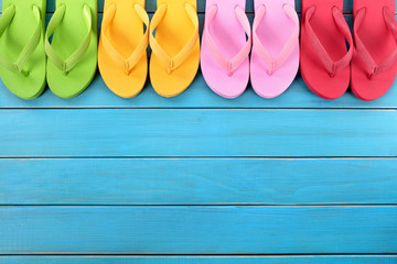 Flip flops or flipflop in a row line top border with old blue wood deck decking summer beach...