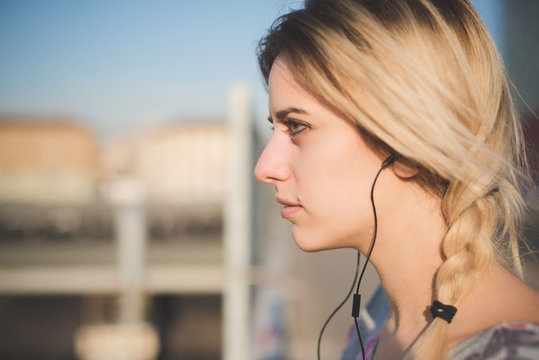 Close up of young woman listening to music outdoors