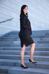 career concept - beautiful business woman standing on stairs
