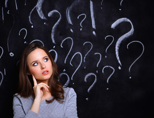 Young girl with question mark on a gray background