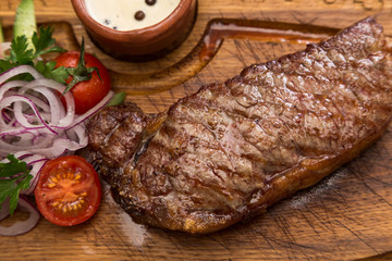 roast meat steak with vegetable garnish and sauce