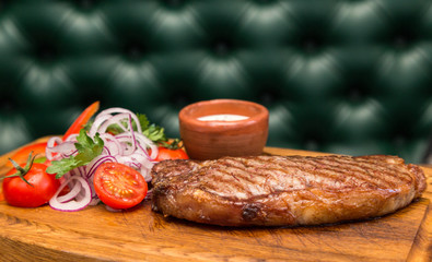 roast meat steak with vegetable garnish and sauce