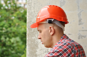 Portrait of a builder in red helmet