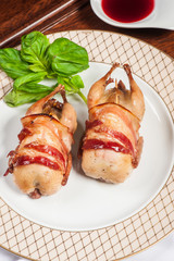 Two fried quails with bacon