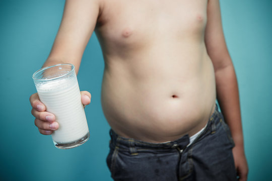 Obese Boy Holding A Glass Of Milk, Healthy And Lose Weight Conce