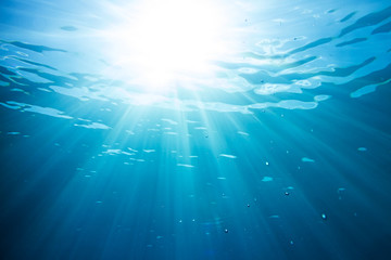 Fototapeta na wymiar sun and sunbeams shining through the surface of blue ocean water