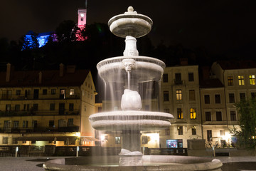 Fountain at night on the background of castle.