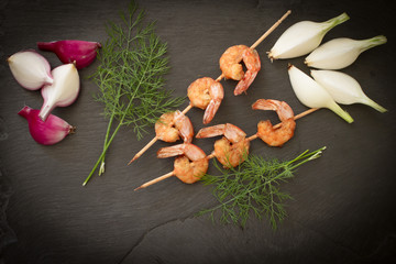 Grilled shrimp with dill on a black stone