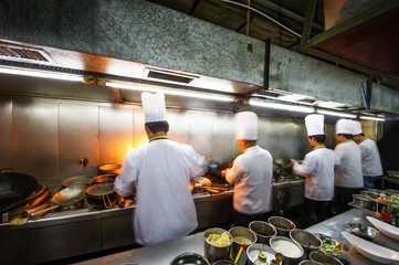 Crowded kitchen, a narrow aisle, working chef.