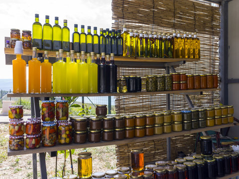 home made colorful liqueur and vinegar bottles on a market in croatia