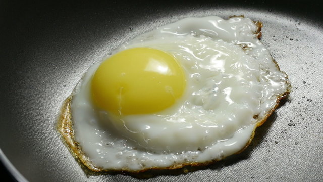 Fried egg. Chef lays out fried egg on a plate. 4k.
