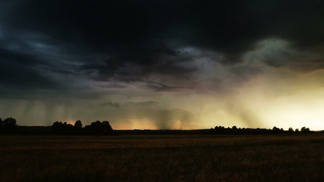 Evening thunder over a farm field. Lightning bolt strike.