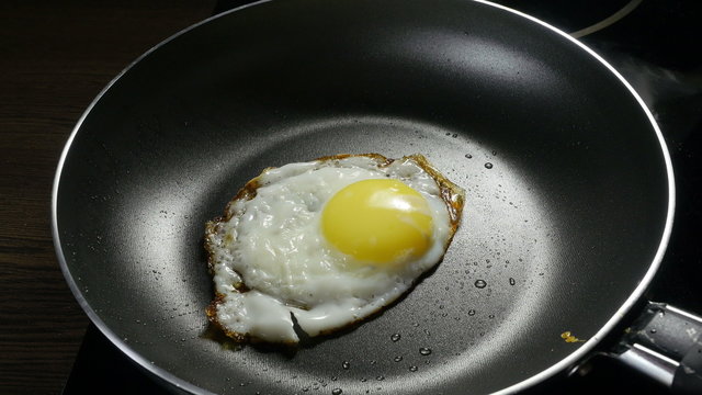 Chef lays out fried egg on a plate. 4k