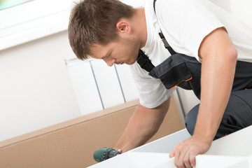 Man putting together self assembly furniture