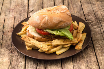 Vegetarian lentil burger in wholewheat bun with lettuce and tomato accompanied by French fries