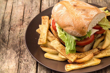 Vegetarian lentil burger in wholewheat bun with lettuce and tomato accompanied by French fries