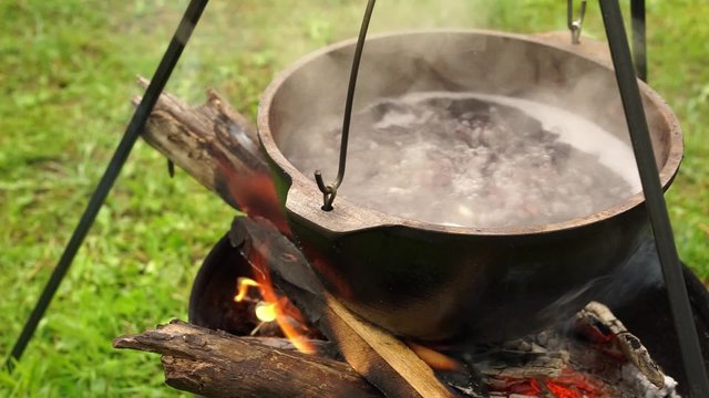 Boiling cooking pot with soup on the fire