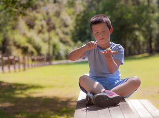 Fototapeta premium niño jugando a la peonza en el parque 