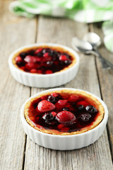 Fresh berry tarts on grey wooden background