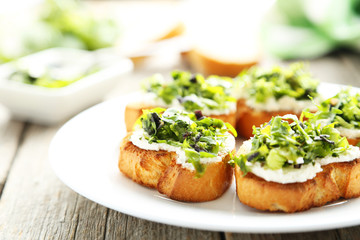 Tasty fresh bruschetta on plate on grey wooden background