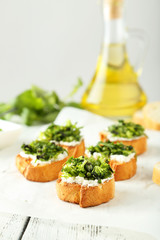 Tasty fresh bruschetta on parchment on white wooden background