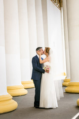 newly married couple kissing at old white columns