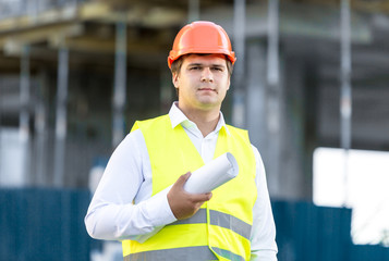 portrait of construction manager posing against scaffolding
