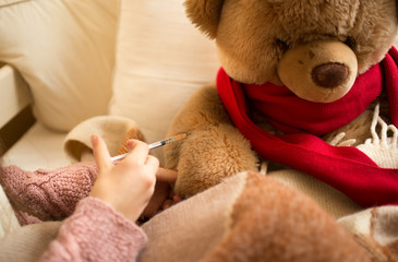 Closeup of little girl doing injection to sick teddy bear