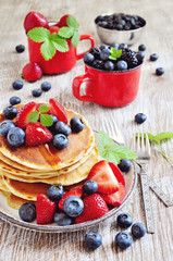 Pancakes with fresh berries, strawberries, blueberries, blackberries, and syrup selective focus