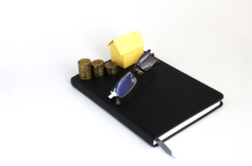 Home paper with coins stack and eyeglasses on business memo for