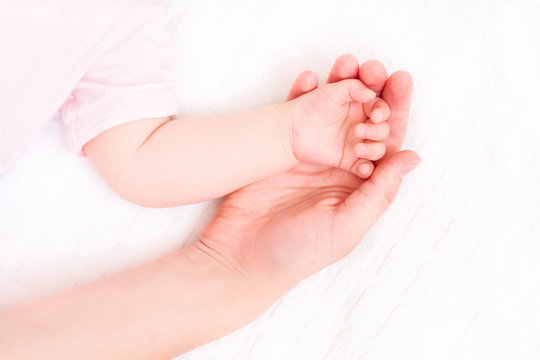 Beautiful sleeping baby with mom hand on white background