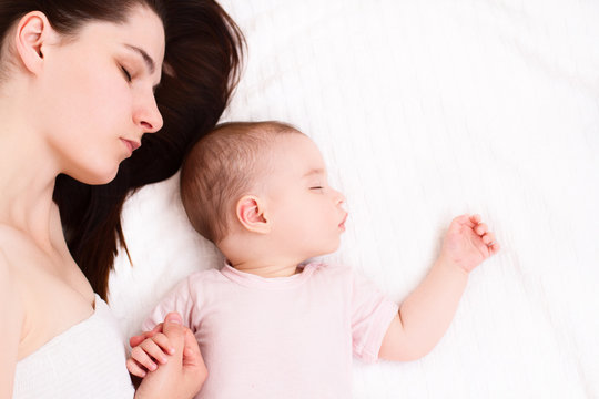 Beautiful sleeping baby with mom on white background