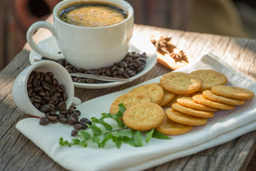 Cup of coffee on a wooden board and biscuits