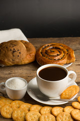 Cup of coffee on a wooden board and biscuits