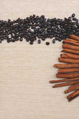 Coffee beans and cinnamon on canvas texture background