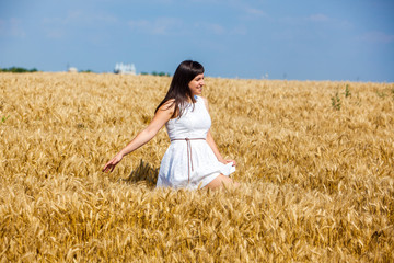 Beautiful girl on a golden field of wheat  enjoy life