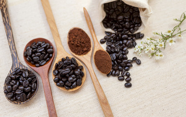 Coffee beans on wooden spoon with flower