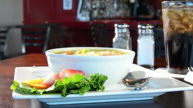 A bowl of shrimp gumbo steaming in a restaurant
